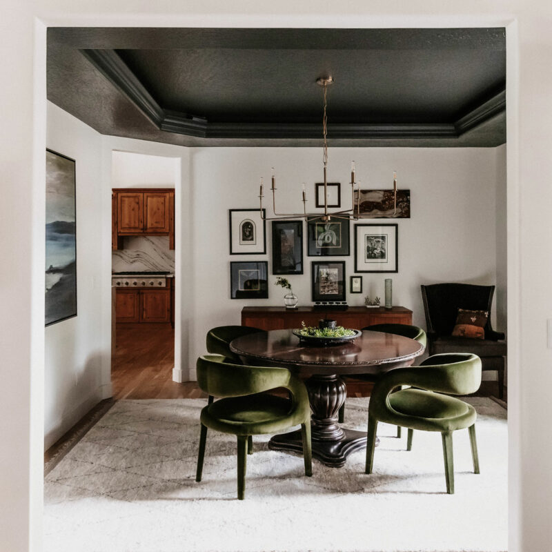 Gorgeous dining room with round table and olive green velvet chairs