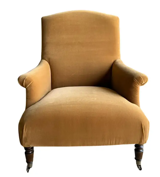 An upholstered tan velvet chair, showing the difference between copying everyone else's style, and coming up with home interior designs that are unique and personal. 