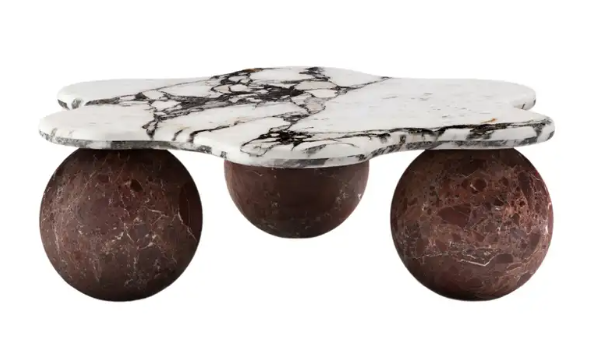 An odd-looking marble platform sitting on top of 3 wooden, or brown stone balls that act as the stand. Showcasing a unique approach to luxury home decor and design. 